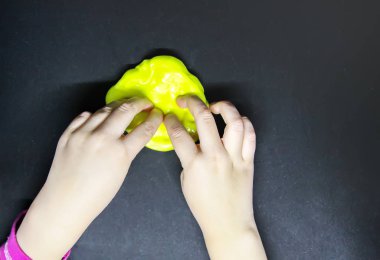 Elinde sarı sümükle oynayan bir kız..