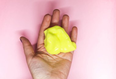 Elinde sarı sümükle oynayan bir kız..