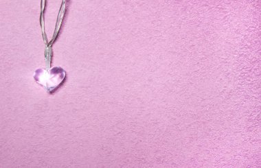 Yumuşak pembe arka planda iki küçük cam kalp. Sevgililer Günü sembolü. Dekoratif unsur. Sevgililer Günü Kartı.