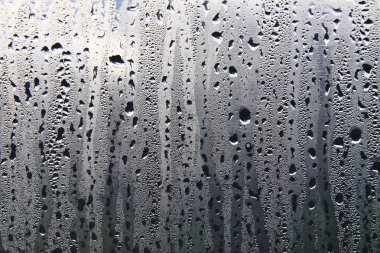 Islak şeffaf yüzeyde yağmur damlaları var. Sulu cam..