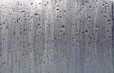 Islak şeffaf yüzeyde yağmur damlaları var. Sulu cam..