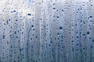 Islak şeffaf yüzeyde yağmur damlaları var. Sulu cam..