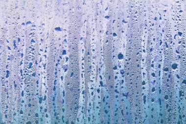 Islak şeffaf yüzeyde yağmur damlaları var. Sulu cam..