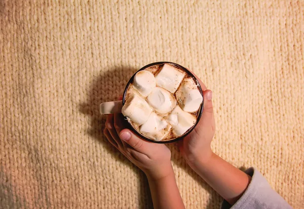 Mãos de criança segurando caneca de cerâmica com bebida quente de cacau fresco com marshmallows — Fotografia de Stock