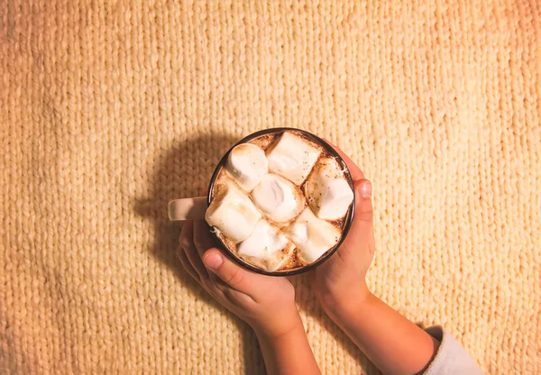 Dětské ruce drží keramický hrnek s horkým čerstvým kakaovým nápojem s marshmallows — Stock fotografie