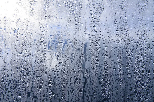 Texture of rain drops on wet transparent surface. Misted glass.
