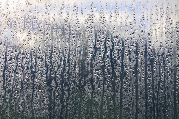 Texture of rain drops on wet transparent surface. Misted glass.