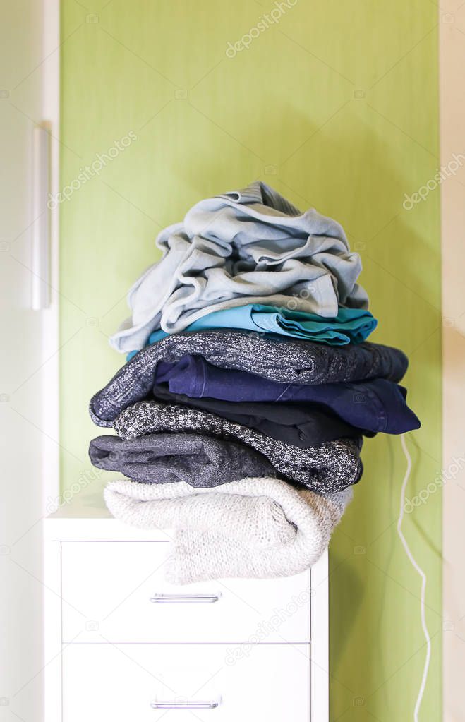 Home wardrobe with different clothes in disorder. Small space organization.