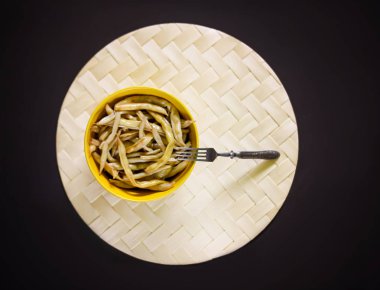 Sarı seramik bardakta kızarmış uzun Fransız fasulyesi..