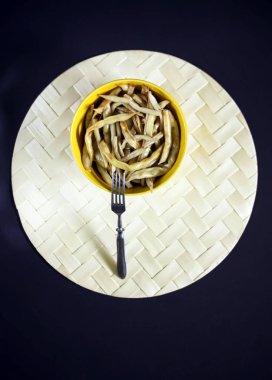 Sarı seramik bardakta kızarmış uzun Fransız fasulyesi..