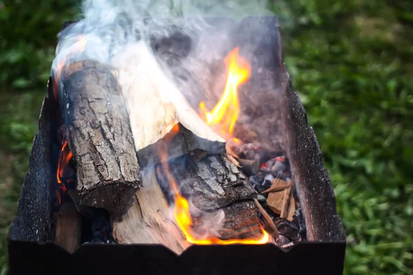 Chama brilhante de madeira queimando no braseiro durante a preparação para cozinhar no churrasco . — Fotografia de Stock
