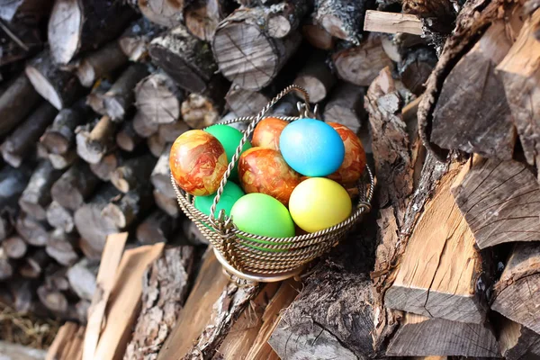 Œufs Pâques Colorés Lumineux Dans Panier Sur Pile Bois Chauffage — Photo