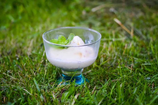 Icecream com folhas de hortelã verde fresco em um vaso transparente no fundo da natureza verão . — Fotografia de Stock