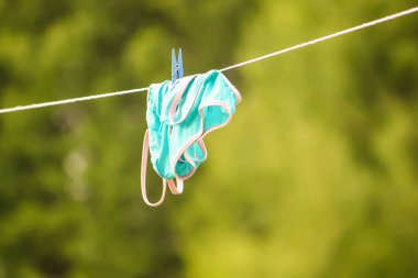 Mavi çocuğun mayosu beyaz koltukta asılı.