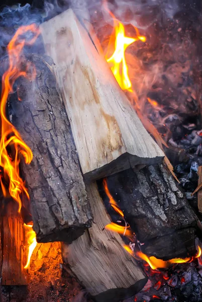 Bright flame of wood burning in brazier during the preparation for cooking on barbecue.