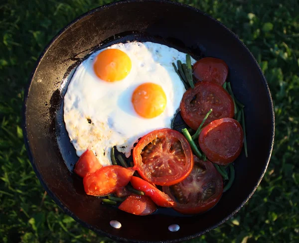 Country style fried eggs with fresh red tomatoes