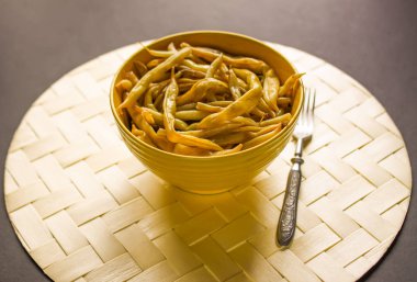 Sarı seramik bardakta kızarmış uzun Fransız fasulyesi..