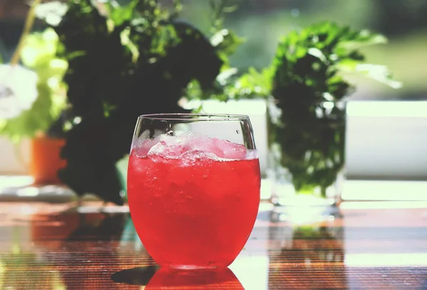 Refreshing cold pink cocktail in a glass with ice