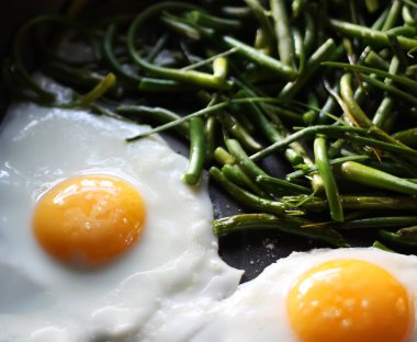 Tavada yeşil fasulyeli sahanda yumurta yakın.