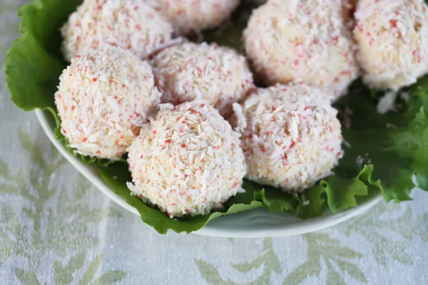 Mavi ahşap masa arkasında salatalı yengeç peyniri topları..