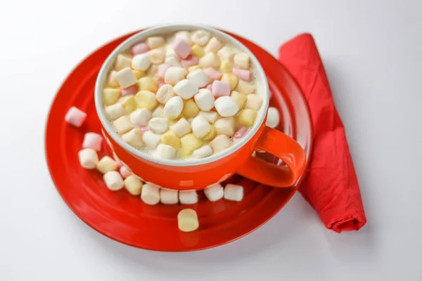 Bebida de cacao con coloridos malvaviscos pequeños sobre fondo rojo — Foto de Stock