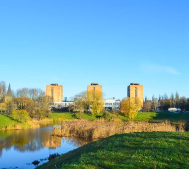 Modern binaları ve göleti olan şehir manzarası.