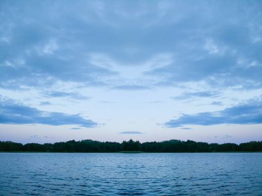 Letonya, Doğu Avrupa 'da sakin bir göl yüzeyi. Yaz günbatımı manzarası Su ve ormanla.