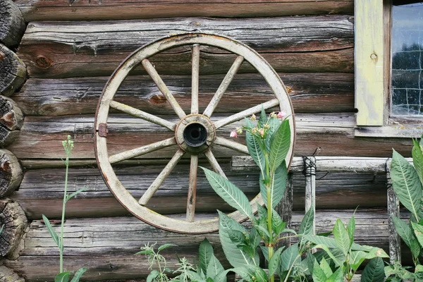 Weathered wall of old barn with wood coach wheel. — Stock Photo, Image