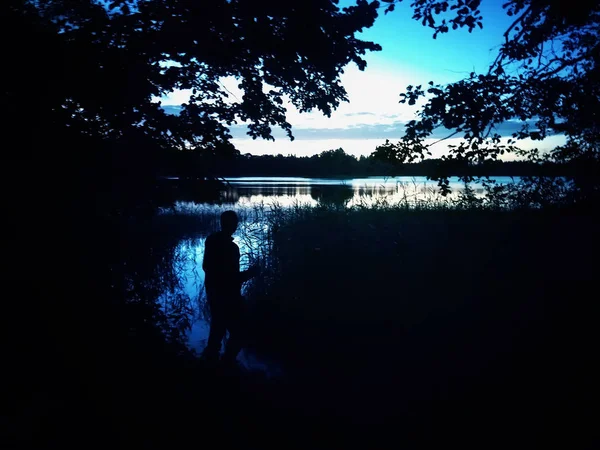 Superfície do lago à noite na Letónia, Europa Oriental. Paisagem com água e floresta . — Fotografia de Stock