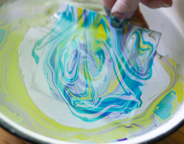 Процесс создания эбру живописи красочными красками, бумагой и деревянной палкой. Яркий абстрактный рисунок в воде
.