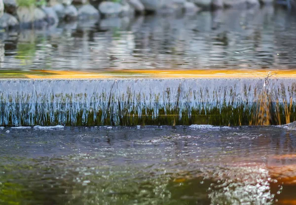 Decoratieve kunstmatige waterval in het zomerpark. — Stockfoto