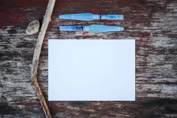 Weißes Papierblatt Und Wasserpinsel Auf Hölzernem Hintergrund — Stockfoto