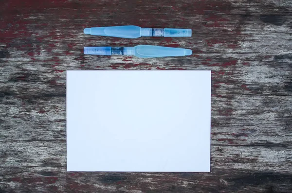 Weißes Papierblatt Und Wasserpinsel Auf Hölzernem Hintergrund — Stockfoto