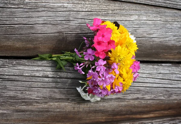 Bouquet von hellen Sommerblumen auf rauen verwitterten Holzwandhintergrund. — Stockfoto