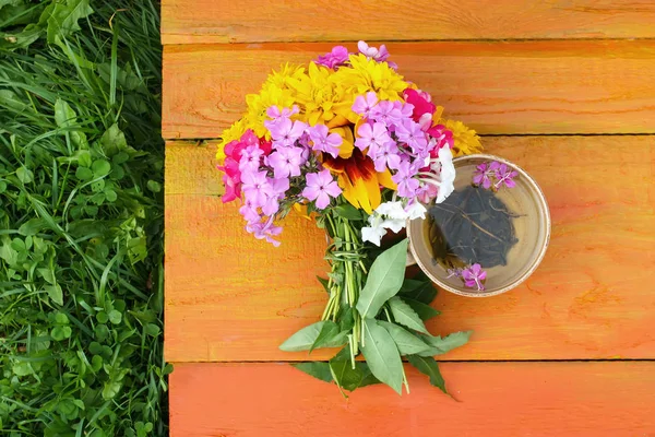 Strauß heller Sommerblumen auf bunten Holzbrettern. — Stockfoto