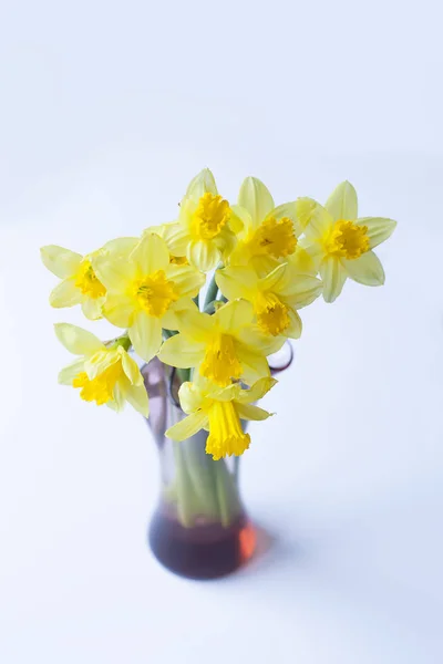 Piękny bukiet wiosennych żółtych kwiatów narcyza w szklanym wazonie. — Zdjęcie stockowe