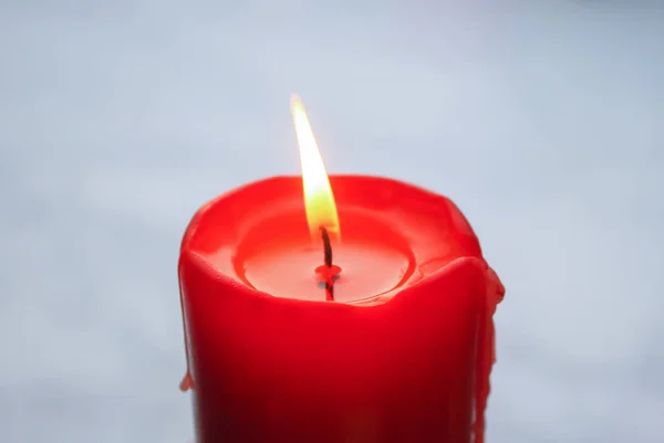 Пламя красной свечи на фоне снега . — стоковое фото