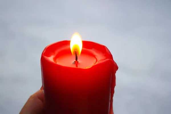 Chama vela vermelha no fundo da neve . — Fotografia de Stock