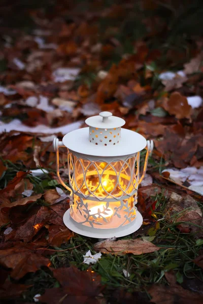 Lanterne décorative avec bougie allumée dans le parc d'automne le soir. — Photo