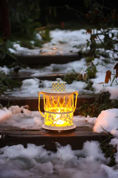 冬の公園の古い木製の階段でろうそくを燃やす装飾的なランタン — ストック写真