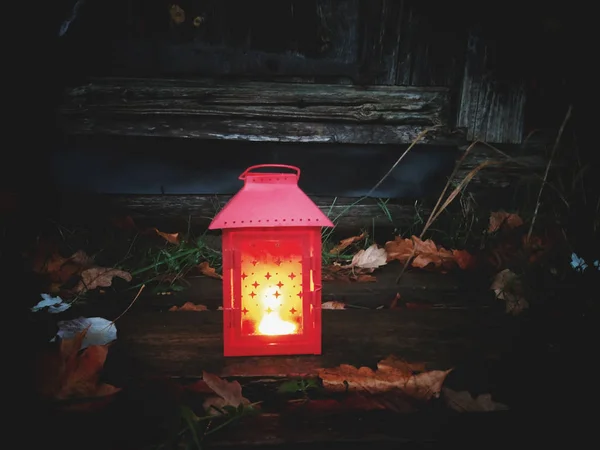 Decoratieve lantaarn met brandende kaars in het najaarspark 's avonds. — Stockfoto