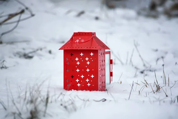 Czerwona latarnia z płonącą świecą na świeżym śniegu. Śnieżny zimowy poranek w parku. — Zdjęcie stockowe
