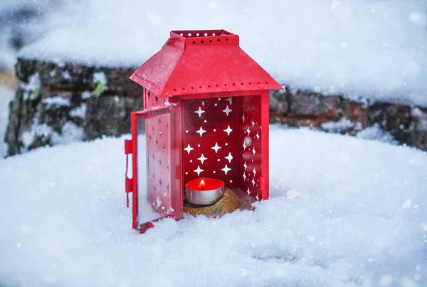 Lanterna rossa con candela accesa sulla neve fresca. Mattina invernale nevosa nel parco . — Foto Stock
