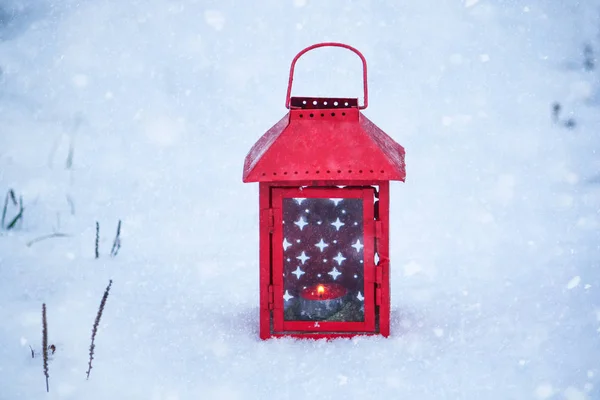 Κόκκινο φανάρι με αναμμένο κερί σε φρέσκο χιόνι. Χιονισμένο πρωινό του χειμώνα στο πάρκο. — Φωτογραφία Αρχείου