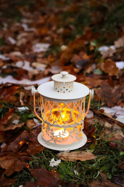 Декоративный фонарь с горящей свечой в осеннем парке вечером . — стоковое фото