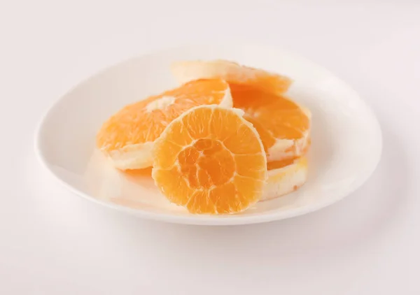 Naranja en rodajas en un plato blanco — Foto de Stock