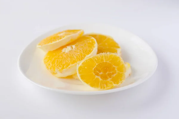 Naranja en rodajas en un plato blanco — Foto de Stock