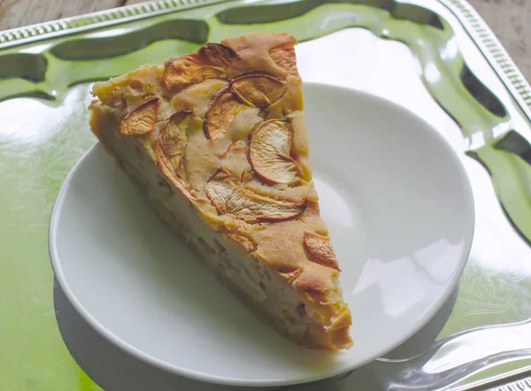 Домашній солодкий яблучний пиріг з корицею та цукровою пудрою на білій тарілці . — стокове фото