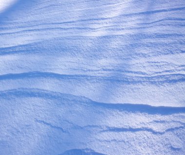 Güneşli kış gününde taze kar yüzeyi.