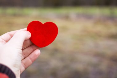 Elinde kırmızı dekoratif bir kalp